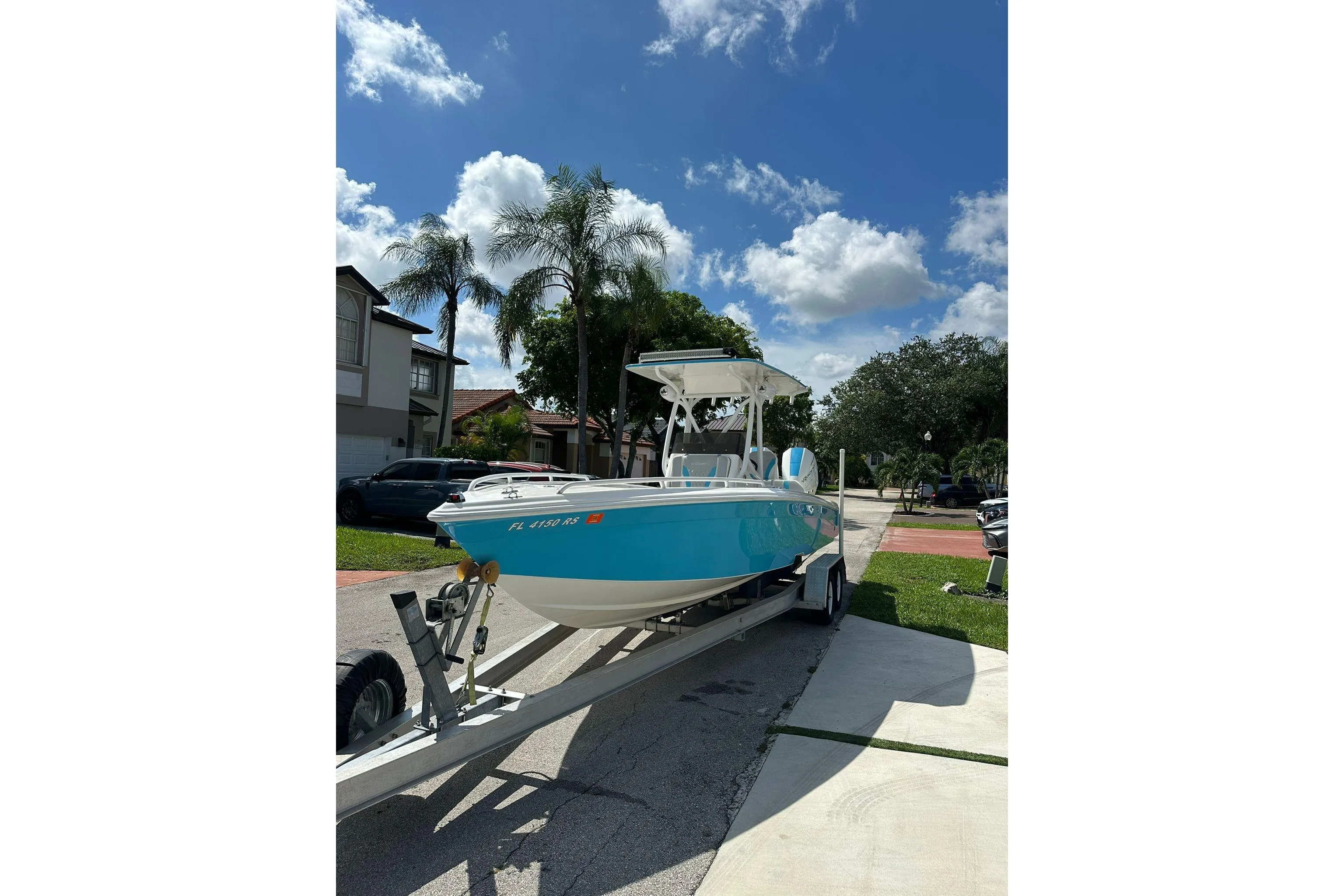 2019 Concept 27' CC boat on trailer under clear blue sky with palm trees.