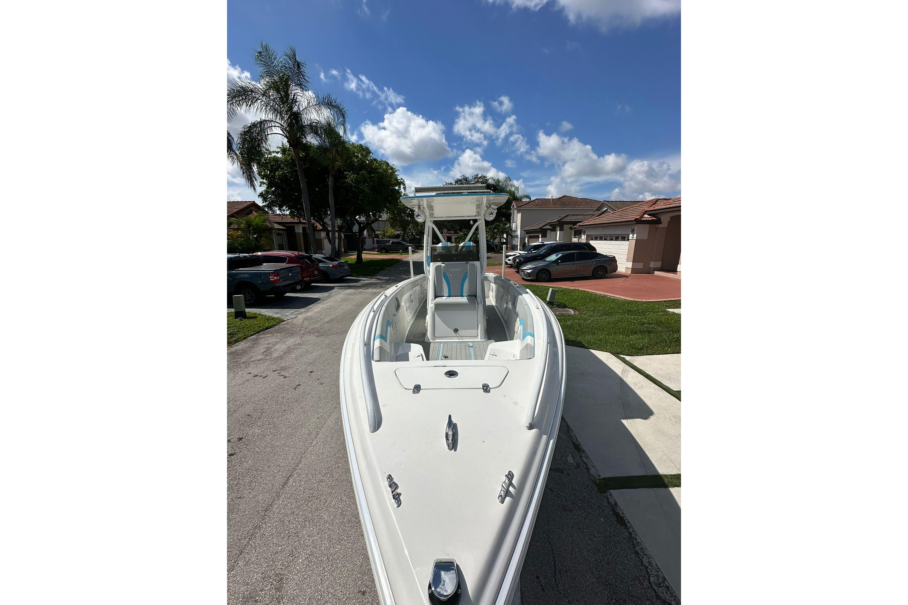 2019 Concept 27' CC boat parked on a residential street under a clear blue sky.