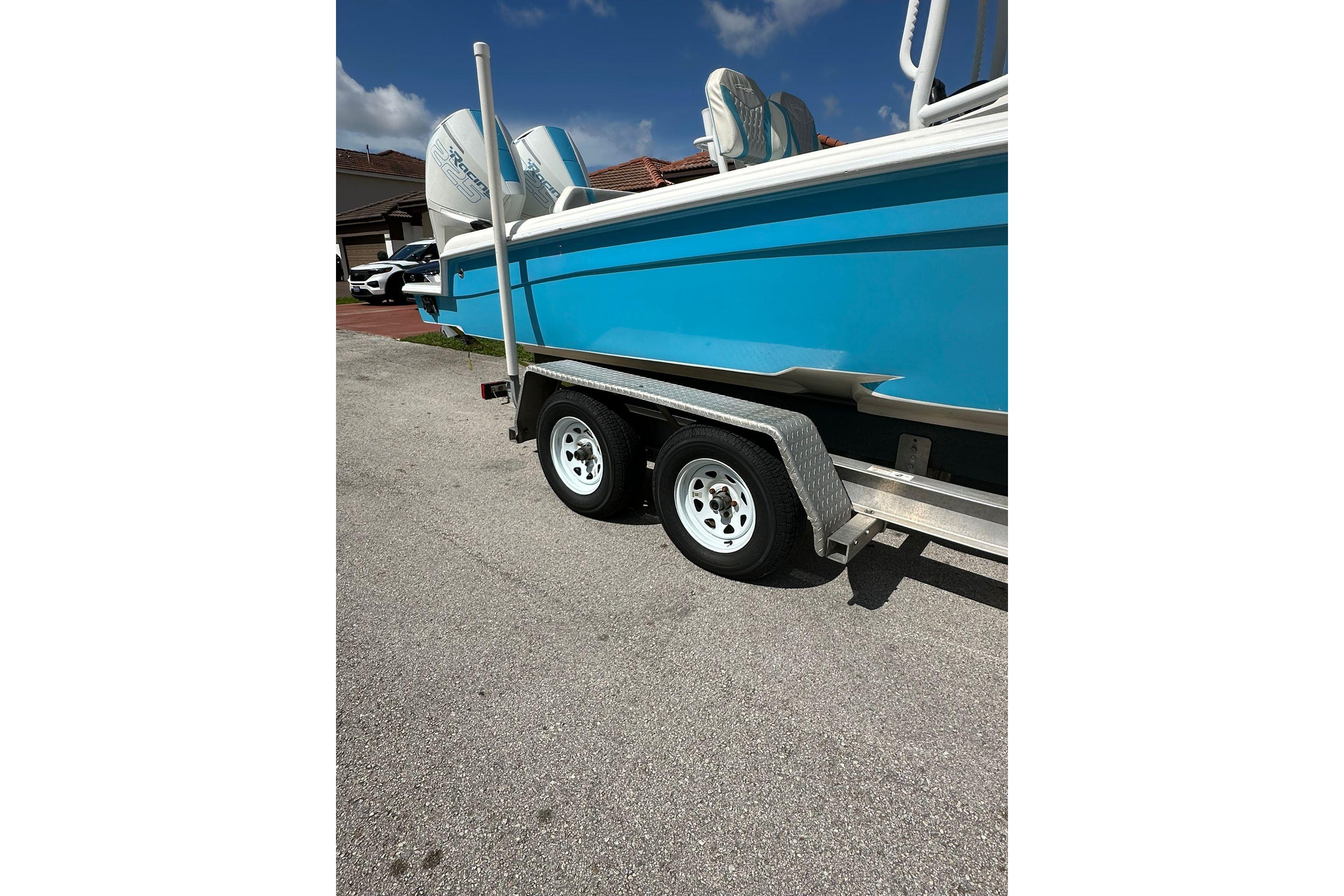 Blue 2019 Concept 27' CC boat on trailer, parked on a sunny street.