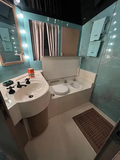  Yacht Photos Pics Luxurious bathroom in 1989 Riva 60 Black Corsair yacht with modern fixtures and elegant design.