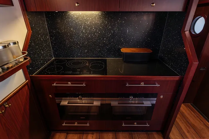 San Gottardo Yacht Photos Pics Luxurious 2009 Altena Expedition yacht kitchen with modern appliances and elegant wood finish.