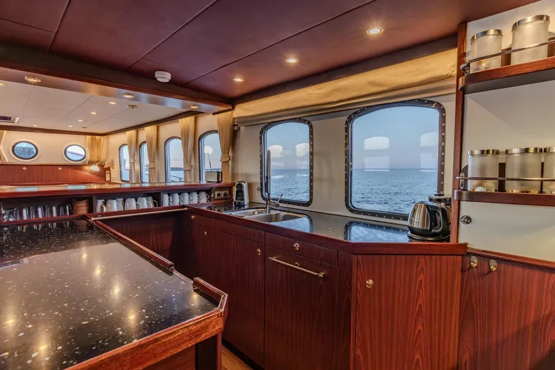 San Gottardo Yacht Photos Pics Luxurious 2009 Altena Expedition yacht interior with elegant wood finishes and ocean view.