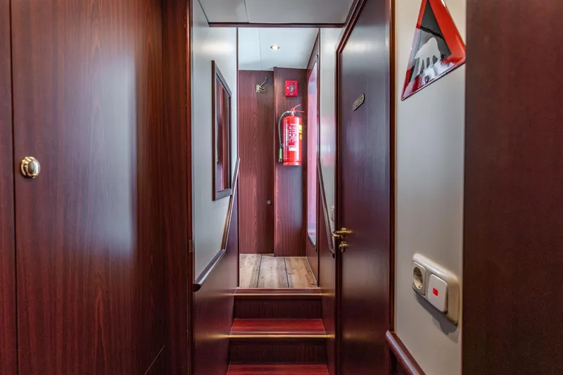 San Gottardo Yacht Photos Pics Interior hallway of 2009 Altena Expedition yacht with wooden paneling and fire extinguisher.
