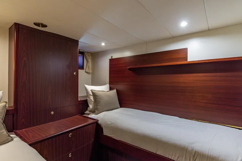 San Gottardo Yacht Photos Pics Luxurious cabin interior of 2009 Altena Expedition yacht with wooden furnishings and cozy bedding.