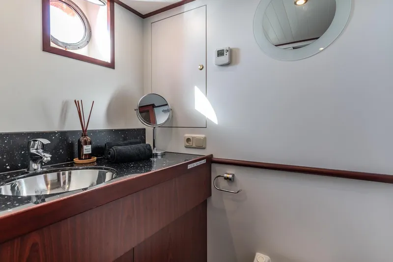 San Gottardo Yacht Photos Pics Luxurious bathroom interior of 2009 Altena Expedition yacht with modern fixtures and porthole window.