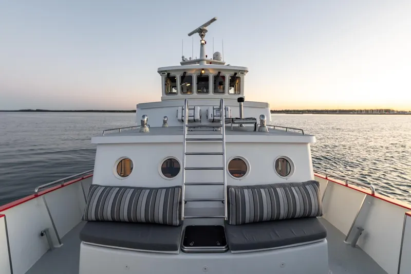San Gottardo Yacht Photos Pics 2009 Altena Expedition yacht on calm water at sunset, featuring a modern design and comfortable seating.