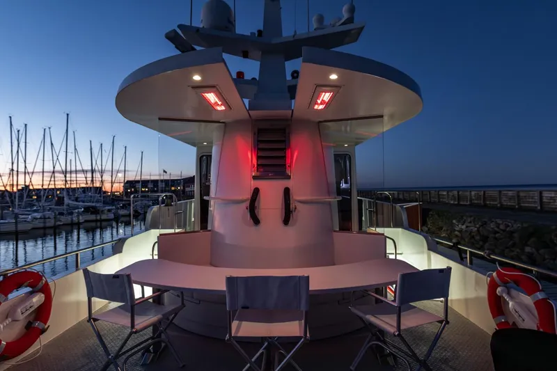 San Gottardo Yacht Photos Pics 2009 Altena Expedition yacht deck at sunset, featuring seating and red lighting.