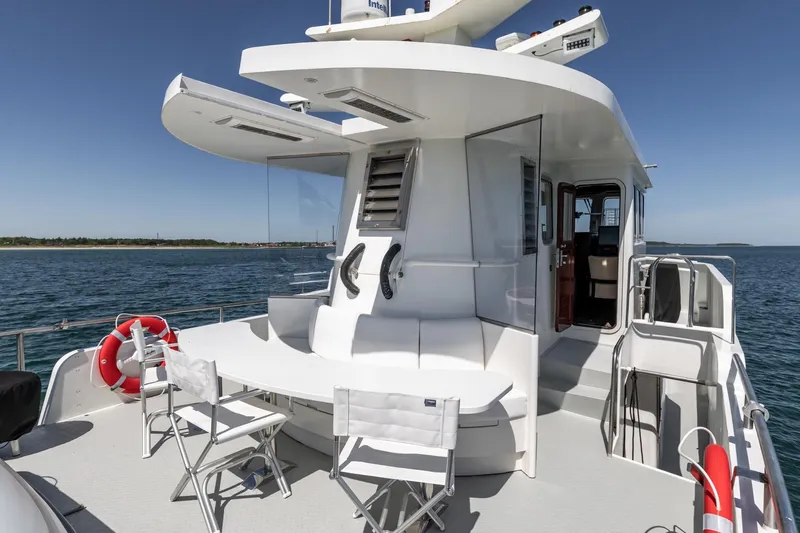 San Gottardo Yacht Photos Pics 2009 Altena Expedition yacht deck with seating, ocean view, and clear blue sky.