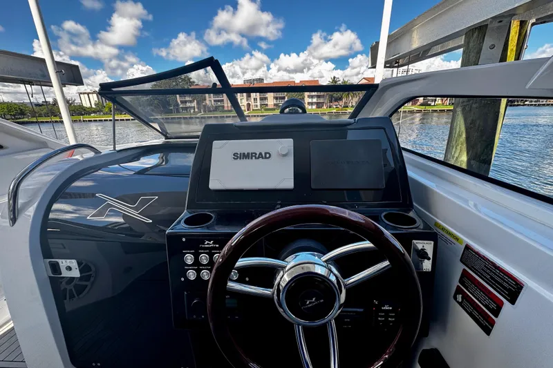  Yacht Photos Pics 2024 NX Boats NX 280 helm with Simrad navigation system, docked by the water.