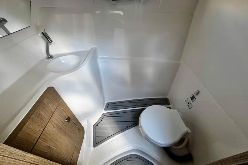 Yacht Photos Pics 2024 NX Boats NX 280 bathroom with modern sink, toilet, and wooden cabinet.