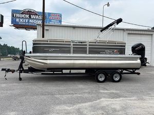 2025 Sun Tracker Party Barge 20 DLX pontoon boat on trailer, parked near a truck wash.