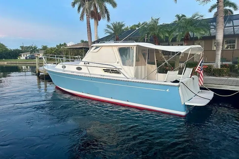  Yacht Photos Pics 2006 Back Cove 29 boat docked by palm trees, featuring a light blue hull.