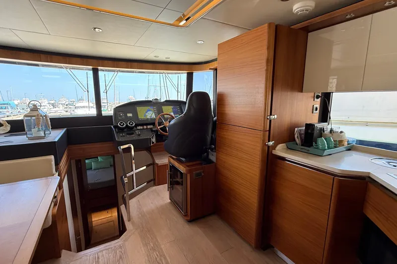 Grace Yacht Photos Pics Interior of 2016 Absolute NAVETTA 58 yacht with helm, wooden cabinetry, and marina view.