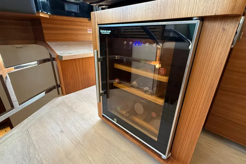 Grace Yacht Photos Pics Wine cooler in 2016 Absolute NAVETTA 58 yacht interior, featuring wooden cabinetry.