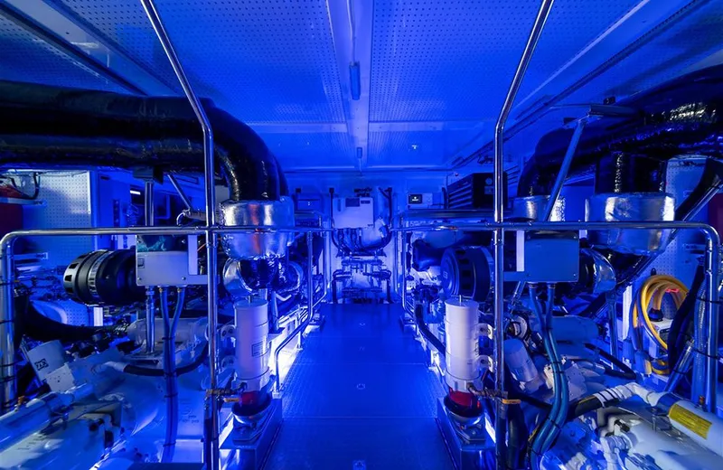 Julianne (name Reserved) Yacht Photos Pics Engine room of 2022 Outer Reef Yachts 900 Motoryacht, illuminated in blue lighting.