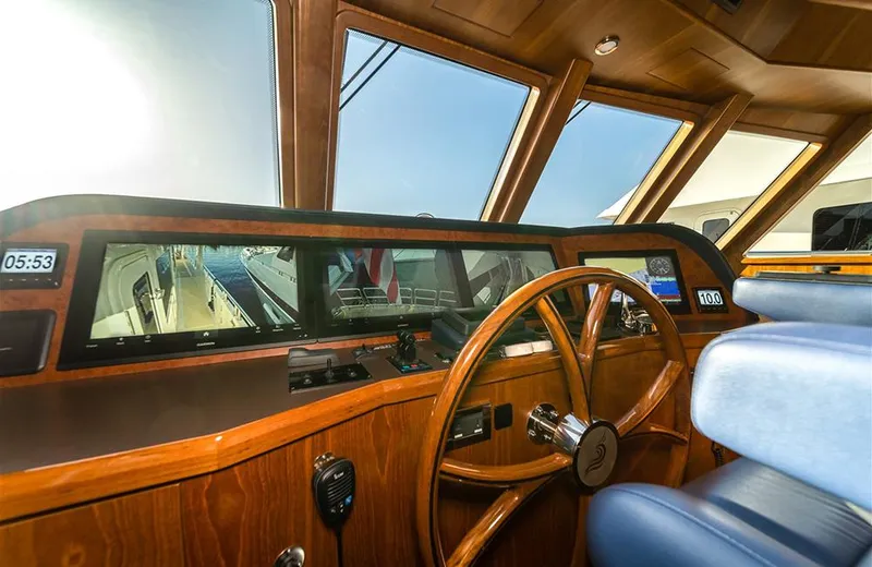 Julianne (name Reserved) Yacht Photos Pics Pilothouse of 2022 Outer Reef Yachts 900 Motoryacht with wooden steering wheel and navigation instruments.