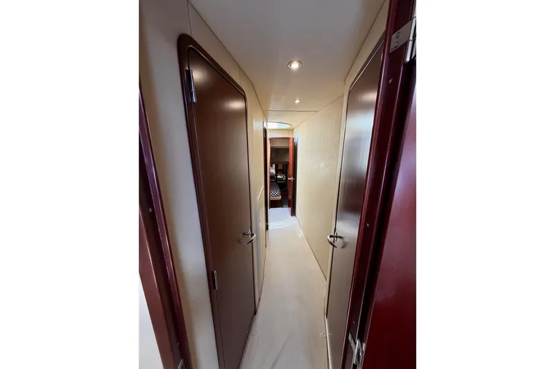 Ponchonchos Yacht Photos Pics Hallway inside 2005 Sea Ray 550 Sedan Bridge yacht, featuring wooden doors and modern lighting.
