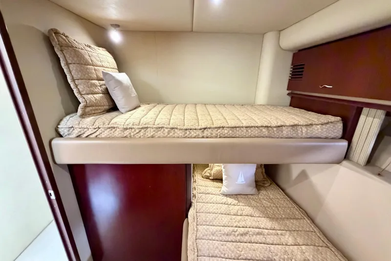 Ponchonchos Yacht Photos Pics Bunk beds in 2005 Sea Ray 550 Sedan Bridge yacht cabin, featuring beige bedding.
