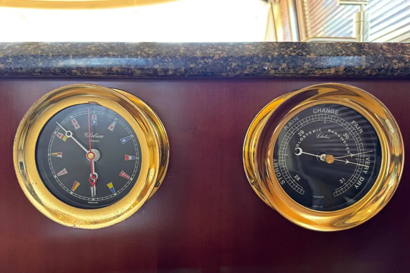 Ponchonchos Yacht Photos Pics Gold-trimmed clock and barometer on 2005 Sea Ray 550 Sedan Bridge yacht dashboard.