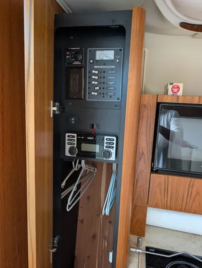 Finale Yacht Photos Pics 2015 Tiara Yachts 3100 Open electrical panel in wooden cabinet interior.