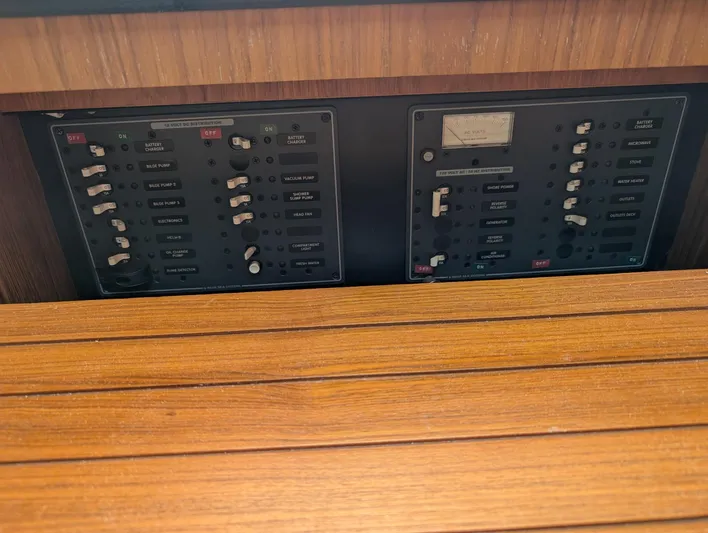 Finale Yacht Photos Pics Control panel of a 2015 Tiara Yachts 3100 Open, featuring switches and wooden trim.