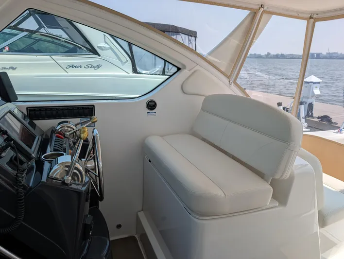 Finale Yacht Photos Pics 2015 Tiara Yachts 3100 Open interior with helm and seating, docked by the water.