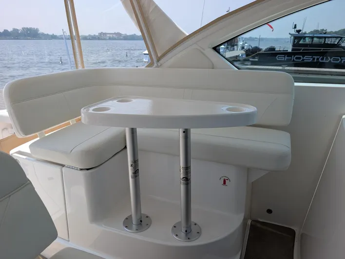 Finale Yacht Photos Pics 2015 Tiara Yachts 3100 Open interior with white seating and table, overlooking water.