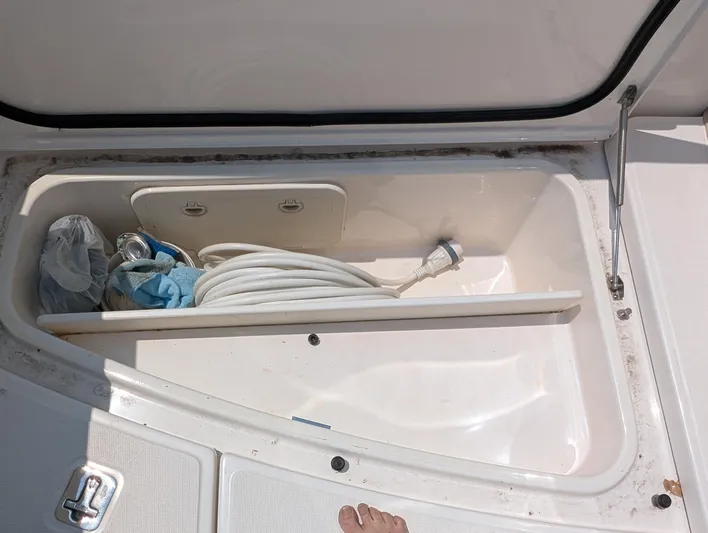 Finale Yacht Photos Pics Open storage compartment on 2015 Tiara Yachts 3100 Open, containing hose and cleaning supplies.