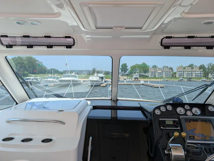 Finale Yacht Photos Pics Interior view of 2015 Tiara Yachts 3100 Open, showcasing helm and marina scenery.