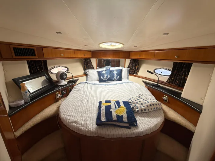  Yacht Photos Pics Luxurious bedroom in 2001 Carver 396 Motor Yacht with cozy bedding and elegant wood finish.