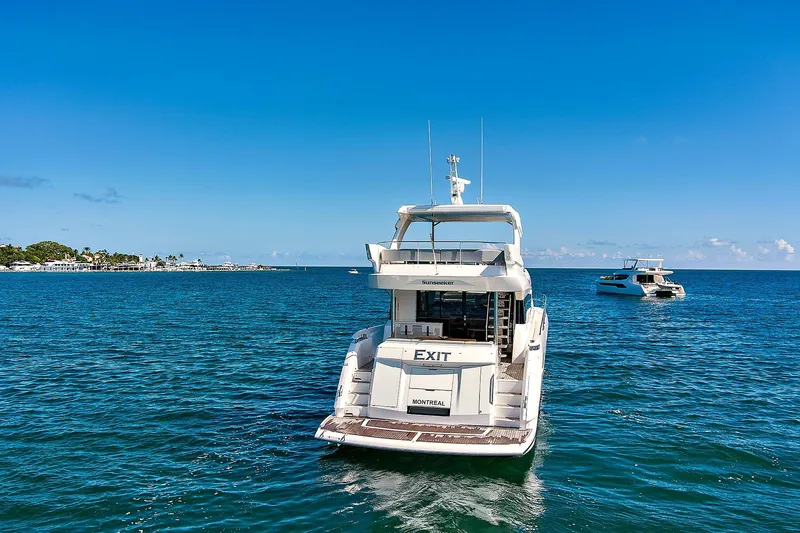 Exit Yacht Photos Pics 2019 Sunseeker Manhattan 66 yacht on open sea, clear blue sky background.