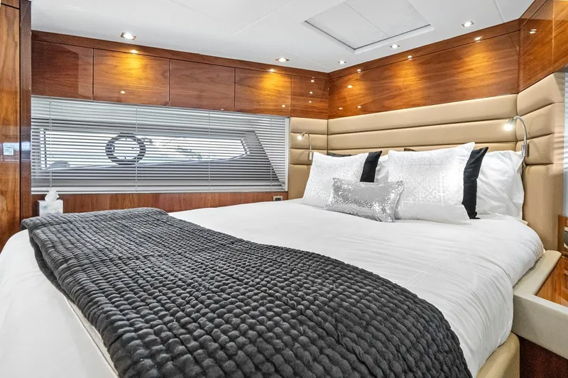 Exit Yacht Photos Pics Luxurious bedroom interior of 2019 Sunseeker Manhattan 66 yacht with elegant wood paneling.