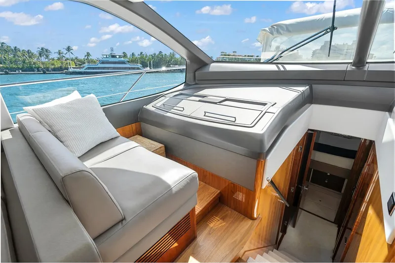 Exit Yacht Photos Pics Luxurious interior of 2019 Sunseeker Manhattan 66 yacht with elegant seating and scenic ocean view.