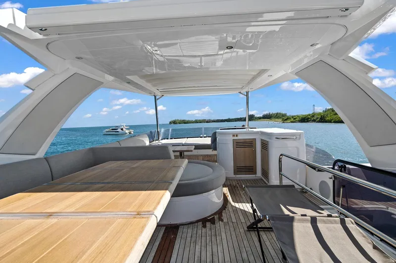 Exit Yacht Photos Pics Luxurious Sunseeker Manhattan 66 yacht deck with seating, ocean view, and clear blue sky.