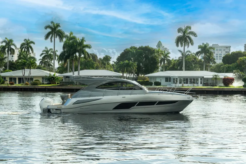  Yacht Photos Pics 2025 Valiatt 410HT luxury yacht cruising on a scenic waterway with palm trees.