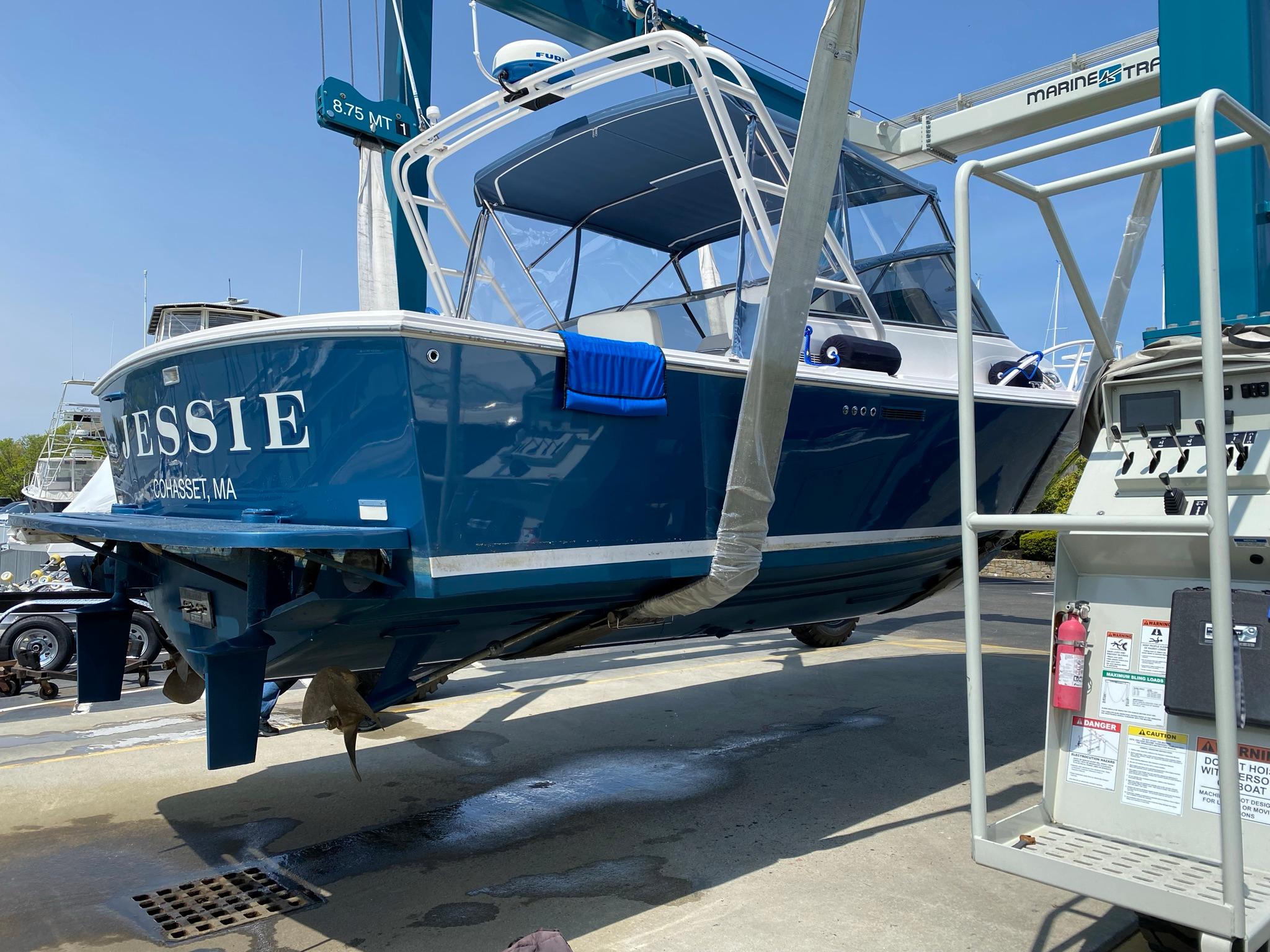 Blue 1995 Blackfin 29-2 Combi boat on lift, named "Jessie," in a marina setting.