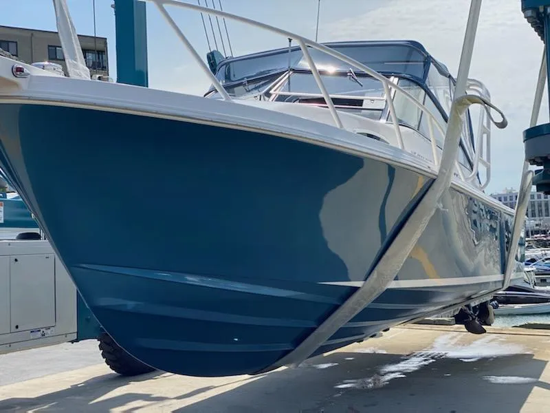 1995 Blackfin 29-2 Combi boat on lift, blue hull, marina background.