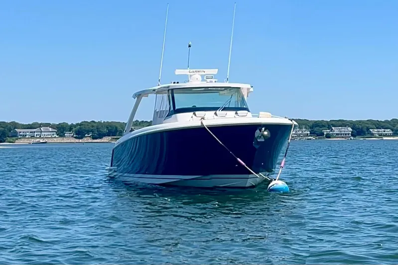 Ivernia Yacht Photos Pics 2020 Tiara Yachts 43 LS boat anchored on calm water with shoreline in background.
