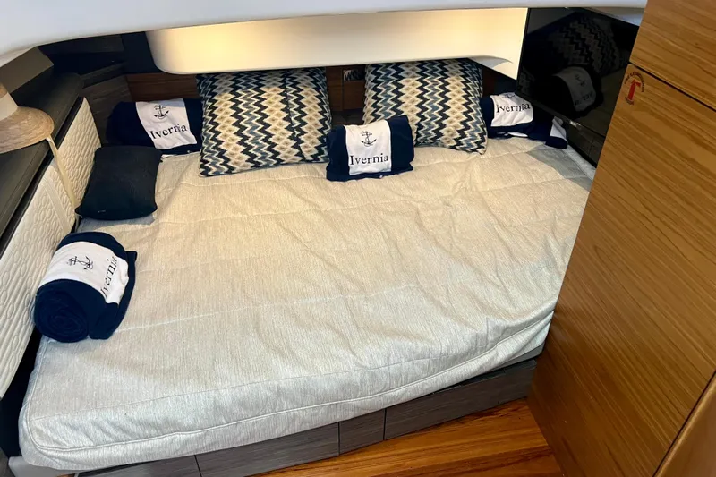 Ivernia Yacht Photos Pics Cozy cabin interior of 2020 Tiara Yachts 43 LS with patterned pillows and branded towels.