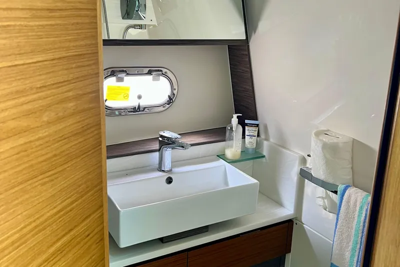 Ivernia Yacht Photos Pics Modern bathroom in 2020 Tiara Yachts 43 LS, featuring sink, mirror, and porthole window.