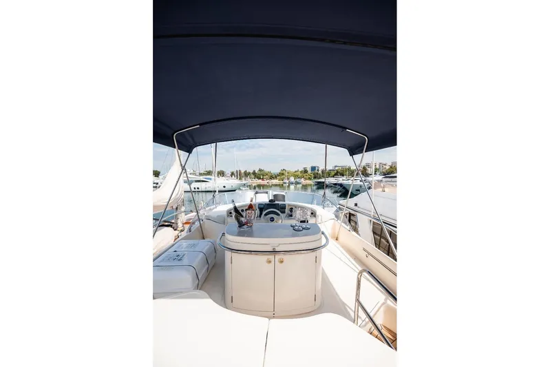  Yacht Photos Pics 2004 Aicon 56 yacht cockpit with canopy, docked in marina, showcasing luxury boating experience.