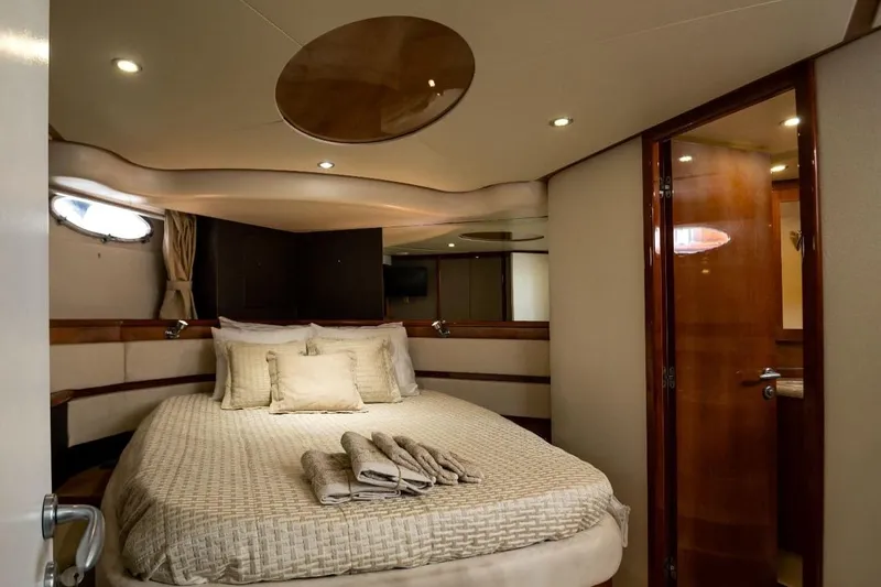  Yacht Photos Pics Luxurious bedroom interior of 2004 Aicon 56 yacht with elegant bedding and wooden accents.