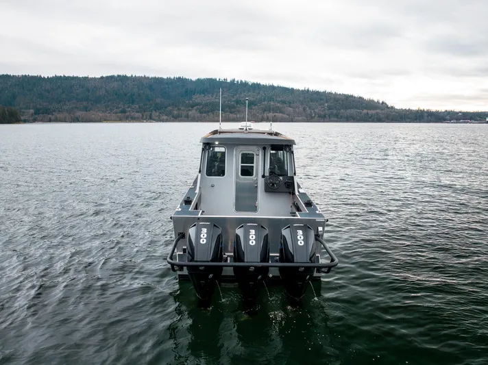  Yacht Photos Pics 2023 Liquid Metal Marine Maquinna Crew boat on calm water with forested shoreline.