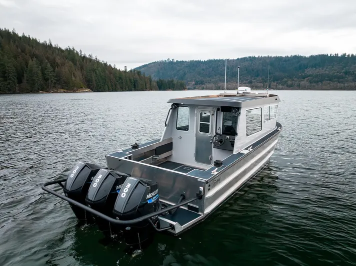  Yacht Photos Pics 2023 Liquid Metal Marine Maquinna Crew boat on a serene lake with forested shoreline.