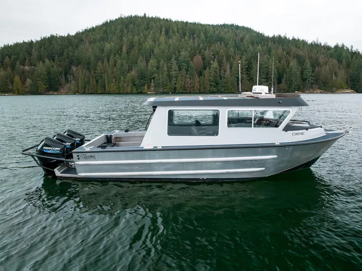  Yacht Photos Pics 2023 Liquid Metal Marine Maquinna Crew boat on a serene lake with forested background.
