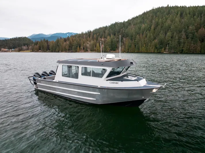  Yacht Photos Pics 2023 Liquid Metal Marine Maquinna Crew boat on a serene lake with forested backdrop.