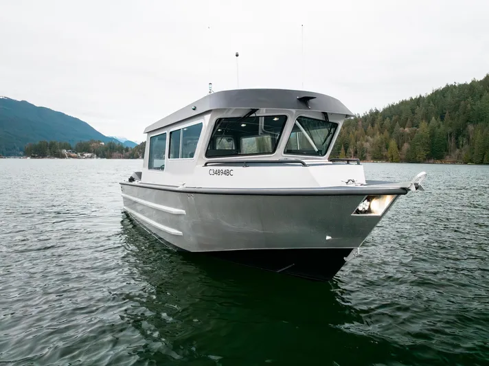  Yacht Photos Pics 2023 Liquid Metal Marine Maquinna Crew boat on a serene lake with forested hills.