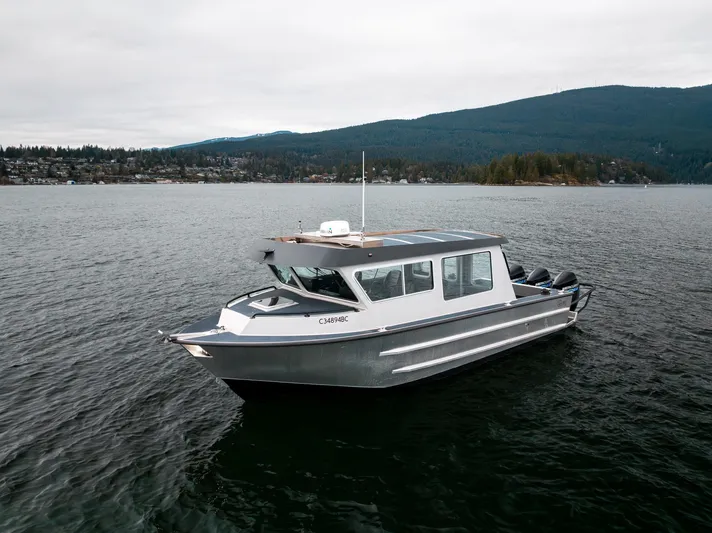  Yacht Photos Pics 2023 Liquid Metal Marine Maquinna Crew boat on calm water with scenic mountain backdrop.
