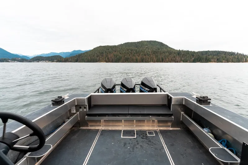  Yacht Photos Pics 2023 Liquid Metal Marine Maquinna Crew boat on a lake with forested hills in the background.