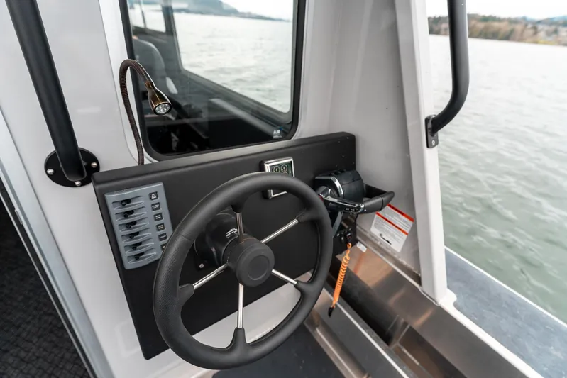  Yacht Photos Pics Steering wheel of 2023 Liquid Metal Marine Maquinna Crew boat, overlooking water.